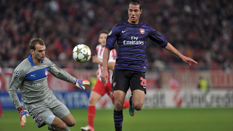 Olympiakos goalkeeper Roy Caroll fights for the ball with Arsenal Mauane Chamakh