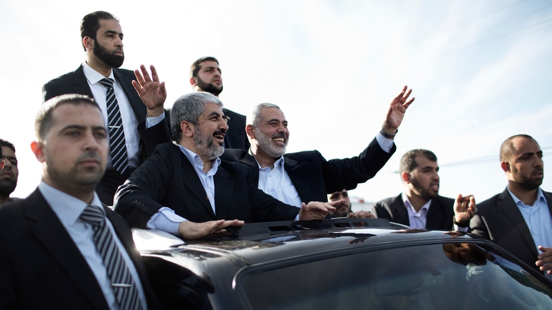 Hamas leader-in-exile Khaled Meshaal (C-L) and Hamas leader in Gaza Ismail Haniya (C-R) wave from the rooftop of a vehicle