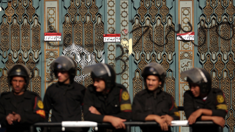 Riot policemen guard the presidential palace in Cairo