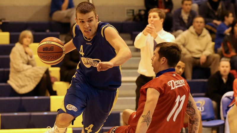 DCU Saints' Keith Anderson charges past Shane Duggan of UCC