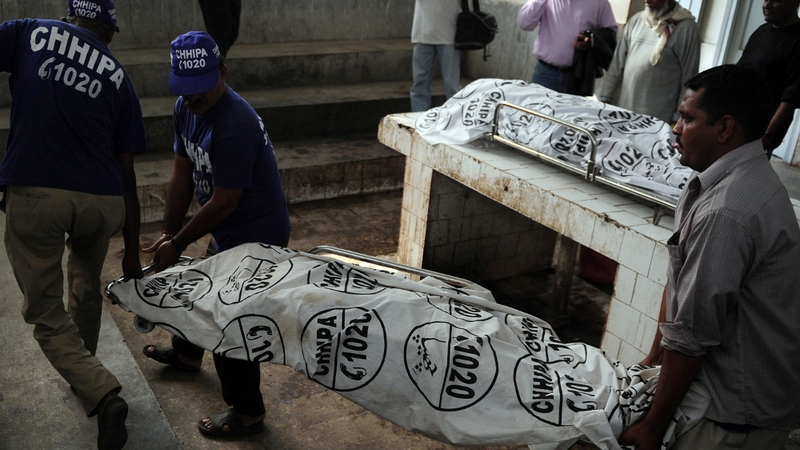 The bodies of health workers shot dead in Pakistan are taken from a morgue