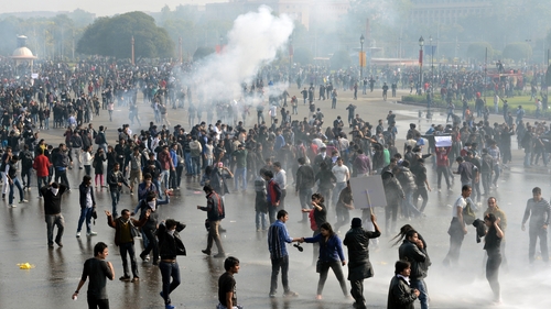 Demonstrators react as police use water cannon and tear gas during a protest