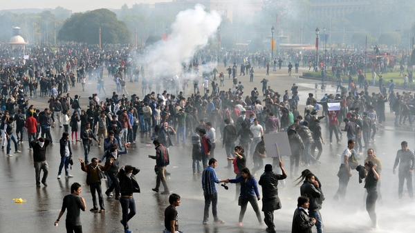 Demonstrators react as police use water cannon and tear gas during a protest