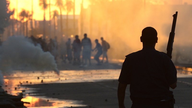 A policeman disperses looters after an attack on a supermarket in San Fernando in Buenos Aires province