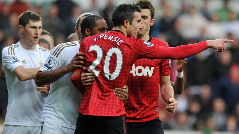 Robin Van Persie reacts after being hit in the head with the ball