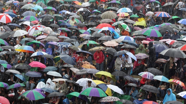 Tennis fans stay in their spots during a torrential downpour on the final day at Wimbledon in July