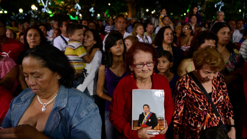 Supporters of Hugo Chavez pray during a mass in Caracas on 31 December