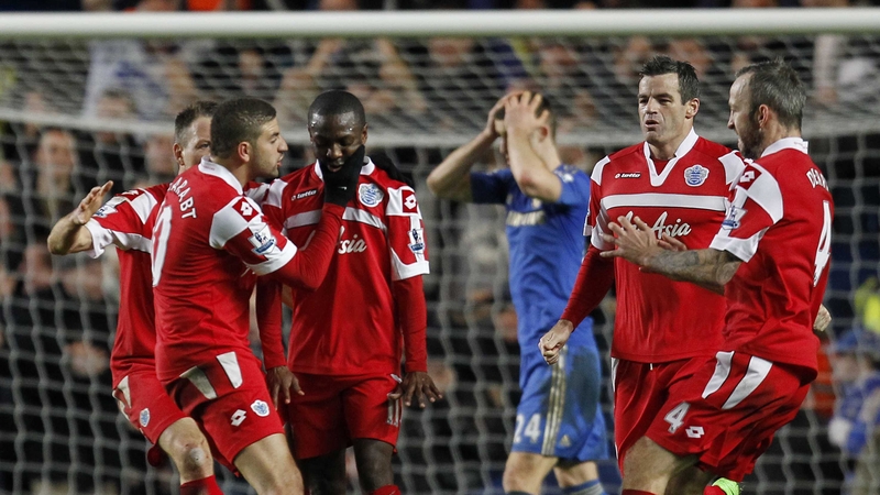 QPR players mob a restrained Shaun Wright-Phillips after his goal at Stamford Bridge