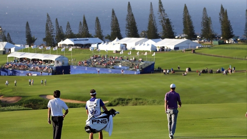 Dustin Johnson (R) walks the 18th fairway in Hawaii