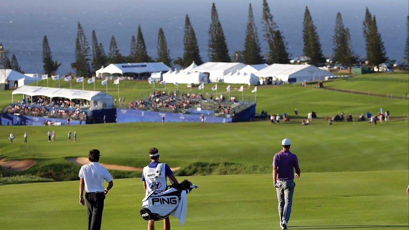 Dustin Johnson (R) walks the 18th fairway in Hawaii