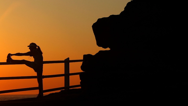 A runner exercises at sunrise to beat the heat in Bronte Beach, Australia