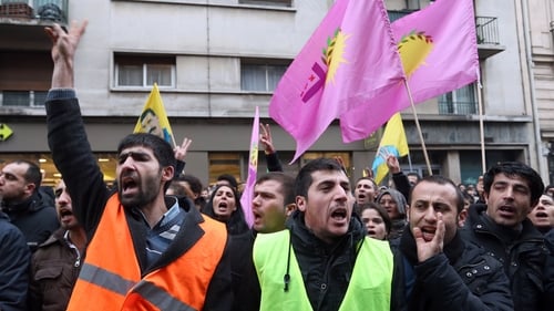 Hundreds of people, including Kurds, gathered on the street near the scene of the murders