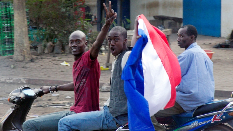 Malian people wave a French flag in Bamako as France send troops to help Malian forces hold back an advance by Islamist rebels