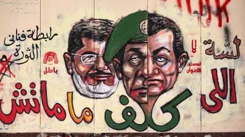 Graffiti depicting Egyptian President Mohamed Morsi (L), ousted president Hosni Mubarak (R) and former head of the army Field Marshal Mohammed Hussein Tantawi