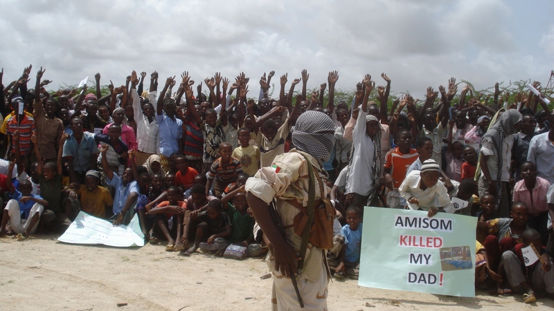 Somali men carry weapons during a demonstration organised by the islamist Al-Shabaab group