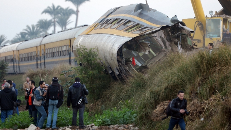 People inspect the wreckage of the train in the Giza in Badrashin, about 40km south of Cairo