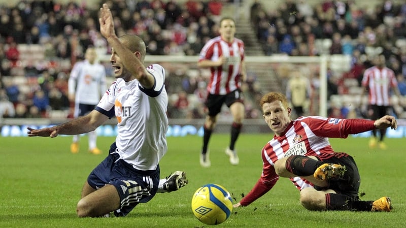 Jack Colback (R) concedes a penalty by tackling Bolton Wanderers' Darren Pratley