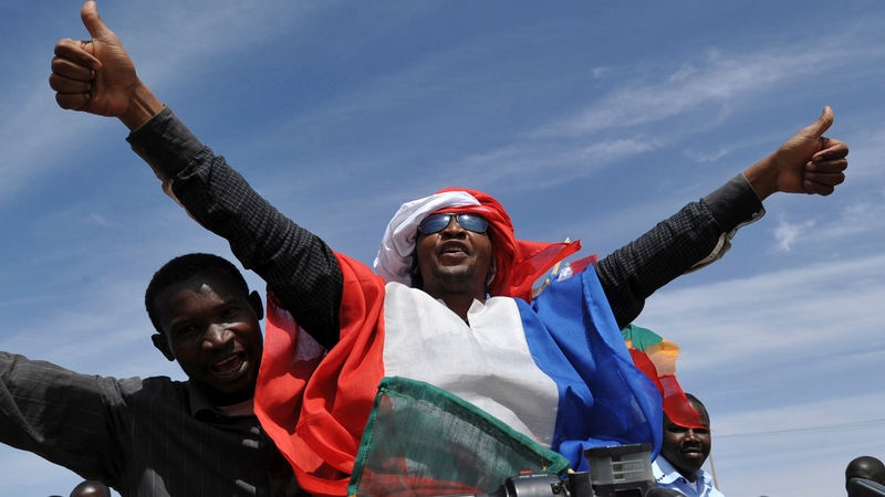 Youths celebrate with the French flag in Ansongo, a town south of the northern Malian city of Gao, as Niger troops enter the city