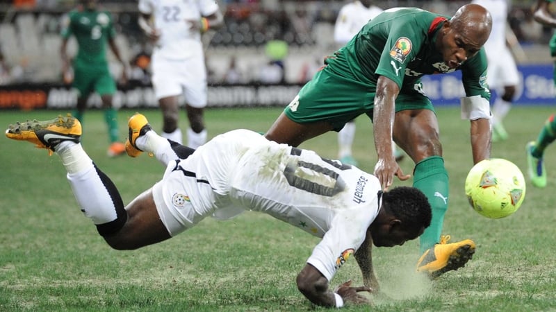 Tumbling Ghana midfielder Kwadwo Asamoah and stumbling Ghana star Charles Kabore fight a losing battle to maintain their footing on a woeful playing surface in Nelspruit