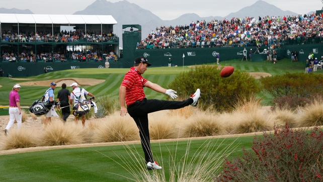 Pádraig Harrington kicks an American football into the grandstands on the 16th hole during the final round of the Waste Management Phoenix Open at TPC Scottsdale