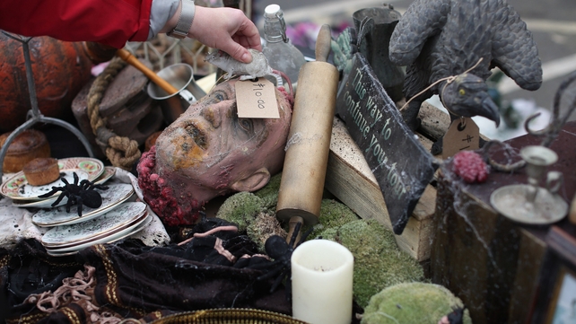A woman arranges props previously used in 'The London Dungeon' which are to be sold at a car boot sale in Pimlico