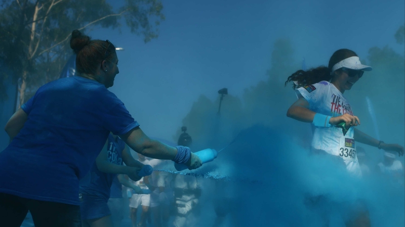 Runners pass through the blue colour throw area at the Colour Run in Sydney
