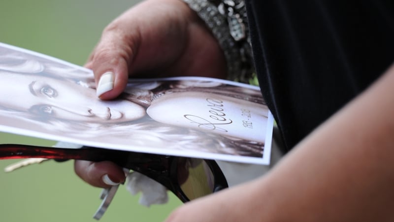 A mourner holds a funeral ceremony programme at the crematorium building in Port Elizabeth