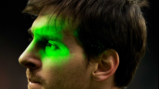 Barcelona's Lionel Messi is illuminated by laser during the la Liga match between Real Madrid and Barcelona at the Bernabeu