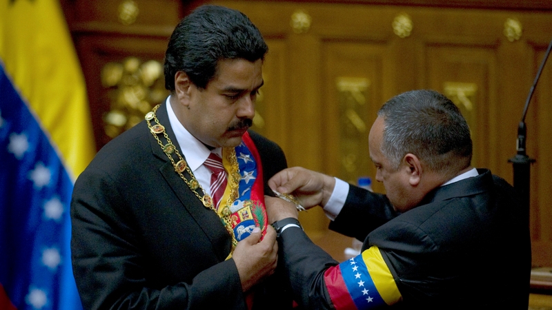 President of the Venezuelan National Assembly Diosdado Cabello puts the presidential sash on Venezuelan Vice President Nicolas Maduro