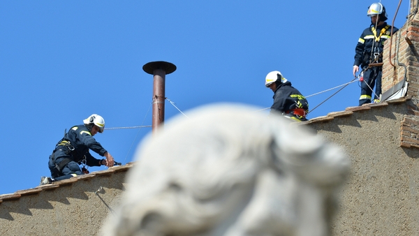 Vatican firefighters set up the chimney on the roof of the Sistine chapel