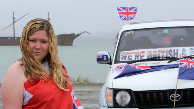 Falkland Islander Sam Davies beside posters calling to vote yes to remain British in the referendum