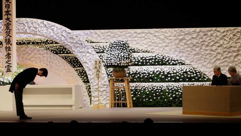 Japanese Prime Minister Shinzo Abe bows to Emperor Akihito and Empress Michiko during a national memorial service for victims