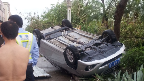 People stand next to an overturned car after the deadly thunderstorm