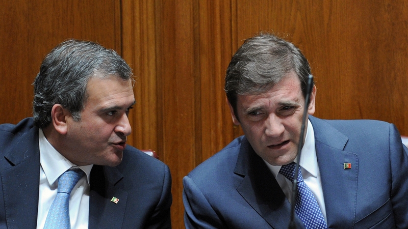 Miguel Relvas (L) chats with Portuguese Prime Minister Pedro Passos Coelho during a parliamentary session last year