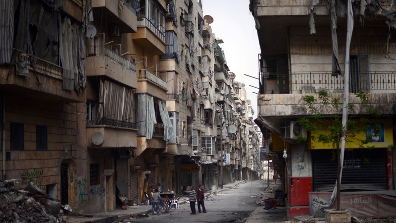 Syrian people stand in the middle of a street in the Saladin district of the northern Syrian city of Aleppo, yesterday