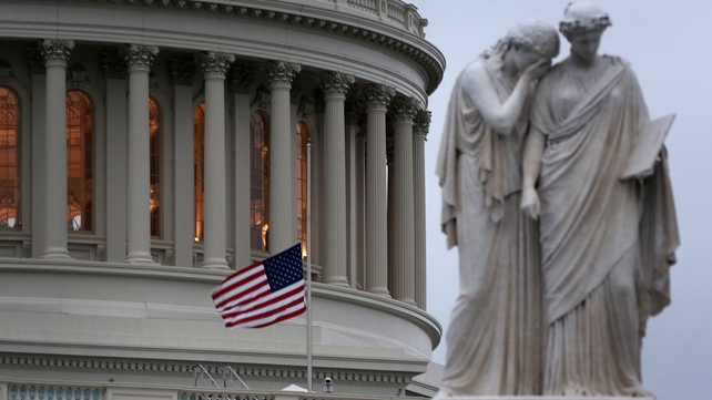 A US flag flies at half mast on the US Capitol in Washington DC