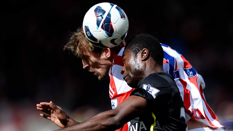 Alexander Tetley of Norwich and Peter Crouch of Stoke compete for a header
