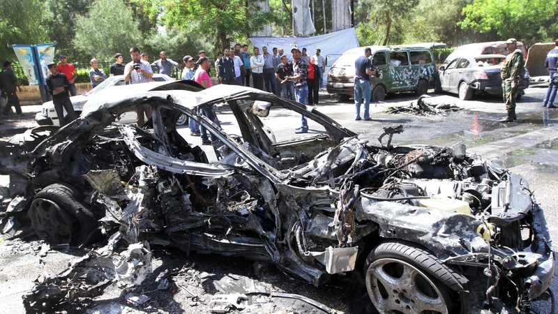 People gather at the scene of the explosion in the Mezze district of Damascus