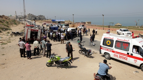 Palestinians gather around the scene following the Israeli raid