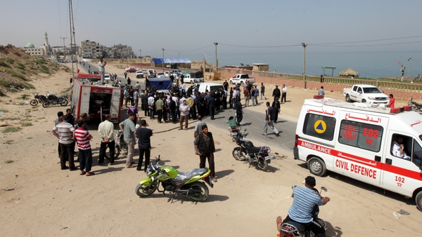 Palestinians gather around the scene following the Israeli raid