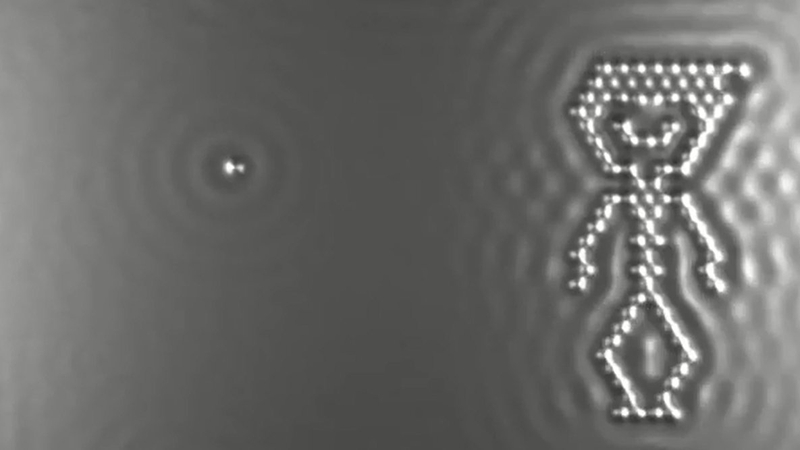 Indvidual carbon monoxide molecules are repeatedly rearranged to show a boy dancing, throwing a ball and bouncing on a trampoline