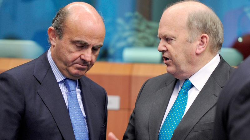 Michael Noonan (R) speaks to Spain's finance minister Luis De Guindos Jurado ahead of Brussels meeting