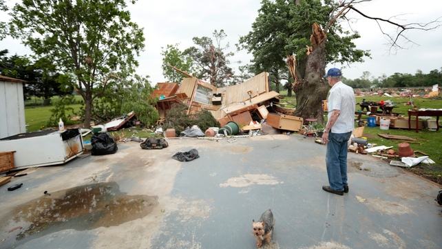 Lonnie Langston stands near his garage, which was swept off the concrete pad next to his house by a tornado