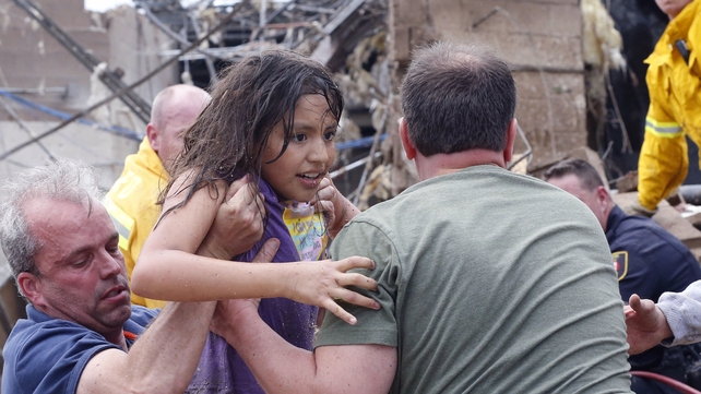 A child is pulled from the rubble of the Plaza Towers Elementary School in Moore