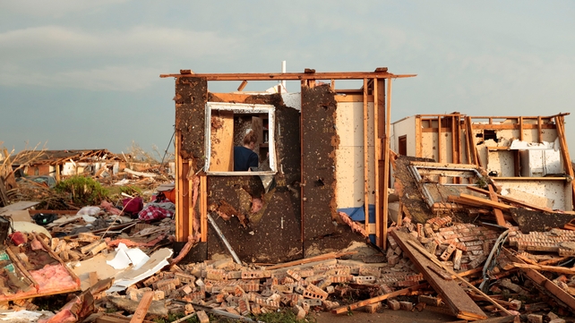 Dana Ulepich searches inside a room left standing at the back of her house in Moore