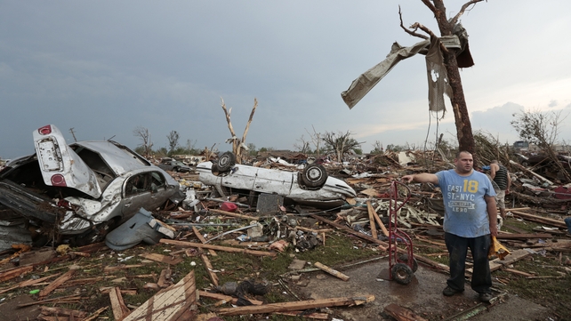 Philip Gotcher stands in the rubble of his house