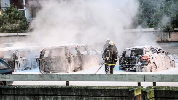 Policemen extinguish burning cars after youths rioted in Husby, northern Stockholm