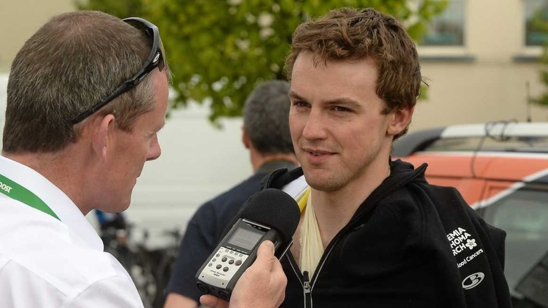 Stage two yellow-jersey holder Peter Hawkins talks to the press; Hawkins had to retire from the race due to a broken collarbone suffered during a crash on stage three