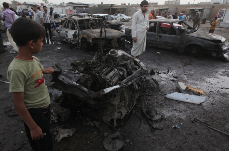 Scene of one of the two car bombs that exploded near an used car dealership in Baghdad's Habibiyah area