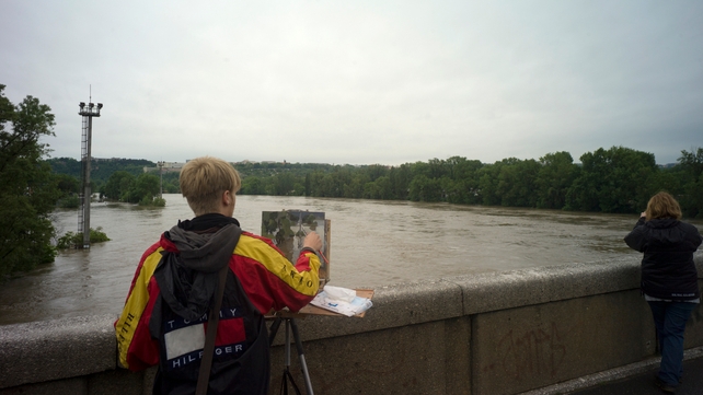An artist paints the overflooding Vltava river in Prague.